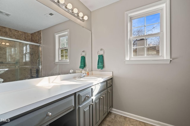 full bath with a stall shower, visible vents, vanity, and baseboards