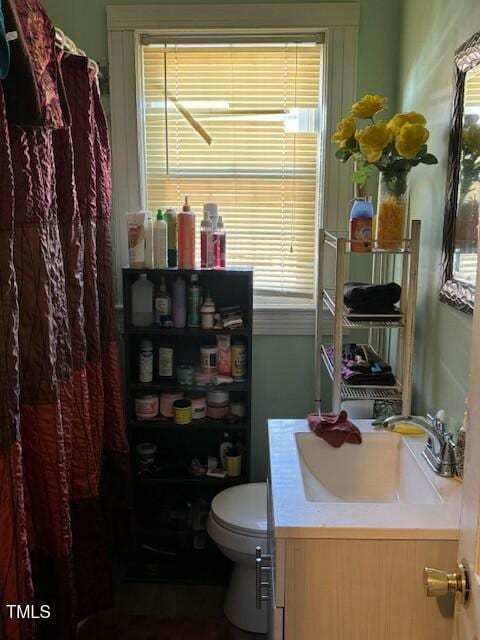 full bathroom with a shower with shower curtain, plenty of natural light, vanity, and toilet