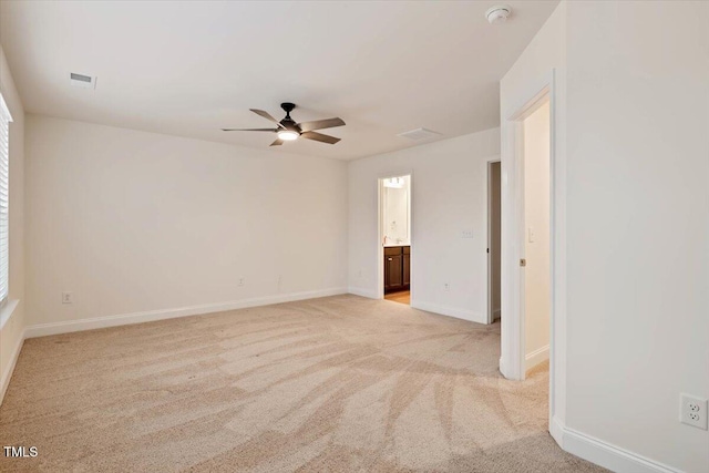 unfurnished room featuring a ceiling fan, visible vents, light carpet, and baseboards