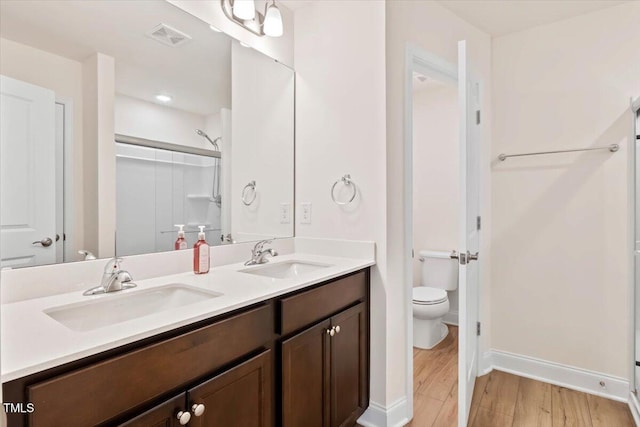 full bathroom featuring a shower, a sink, toilet, and wood finished floors