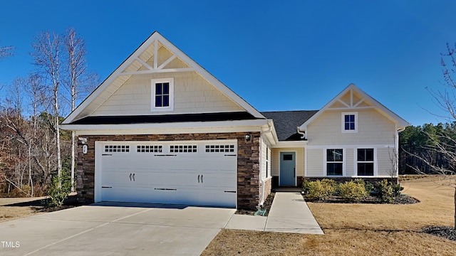 view of front facade with driveway and stone siding