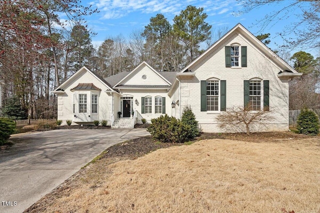 view of front of house with a front lawn and brick siding