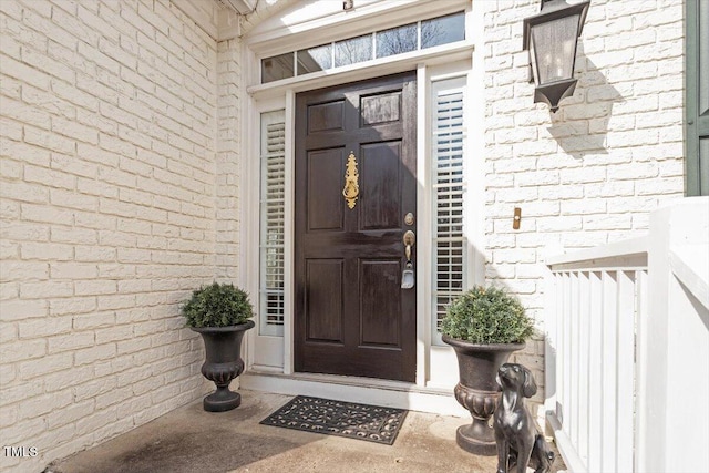 doorway to property with brick siding