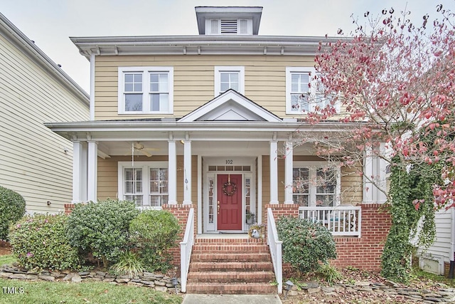 italianate-style house featuring a porch and brick siding