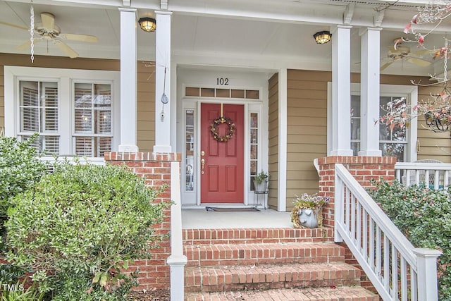 doorway to property featuring brick siding and a ceiling fan