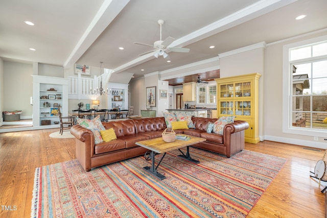 living area featuring ornamental molding, light wood-type flooring, beam ceiling, and recessed lighting