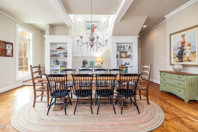 dining area featuring ornamental molding, baseboards, a notable chandelier, and light wood finished floors