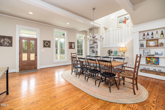 dining room with light wood finished floors, recessed lighting, an inviting chandelier, ornamental molding, and baseboards