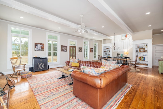 living area featuring light wood-style floors, recessed lighting, crown molding, and beamed ceiling