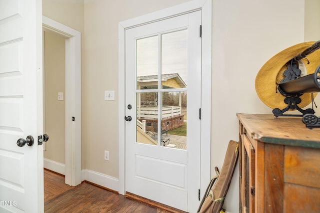 doorway featuring baseboards and dark wood finished floors