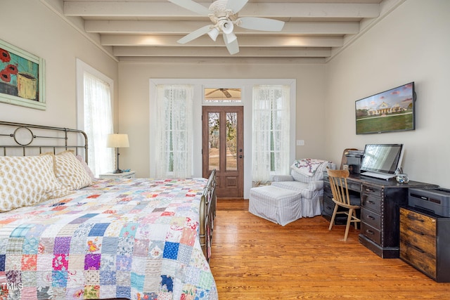 bedroom featuring light wood-style floors, multiple windows, and beam ceiling