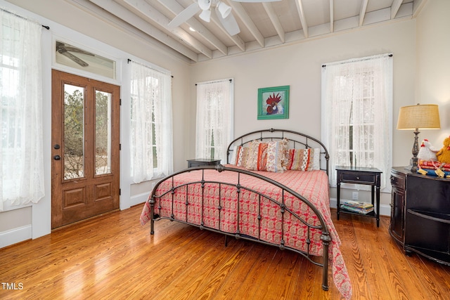 bedroom featuring ceiling fan, beamed ceiling, baseboards, and wood finished floors