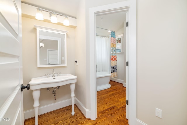 bathroom with baseboards and wood finished floors