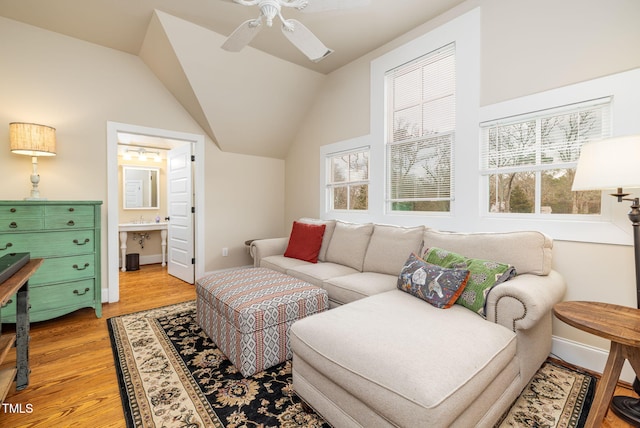 living room with light wood-type flooring, vaulted ceiling, plenty of natural light, and ceiling fan