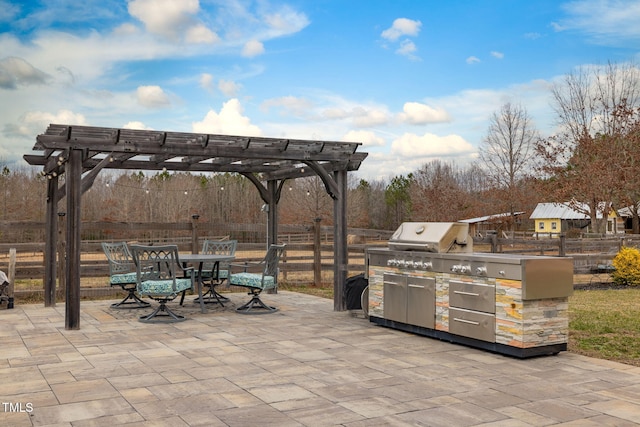 view of patio / terrace with an outdoor kitchen, grilling area, fence, a pergola, and outdoor dining space