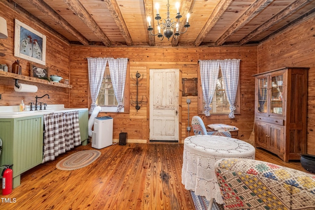 dining area with an inviting chandelier, wood finished floors, wood ceiling, and wooden walls