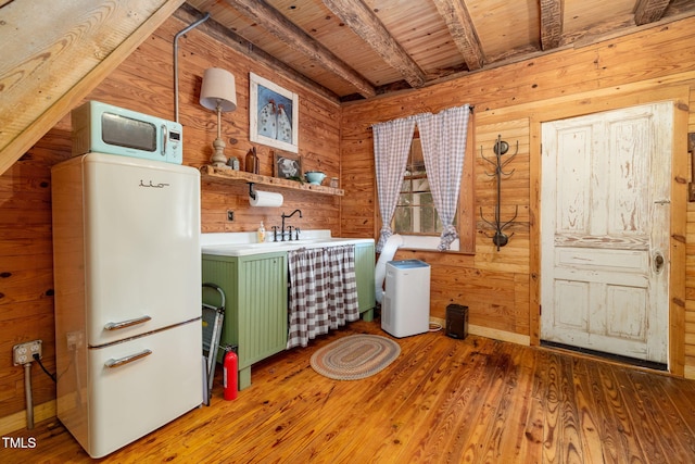 laundry area with a sink, wooden ceiling, wooden walls, and wood finished floors