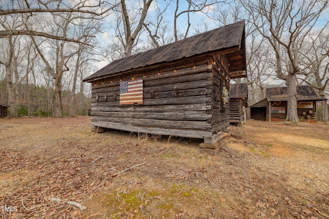 view of side of home with metal roof and an outbuilding