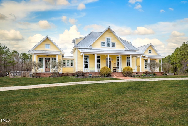 view of front of home with crawl space, metal roof, a porch, and a front yard