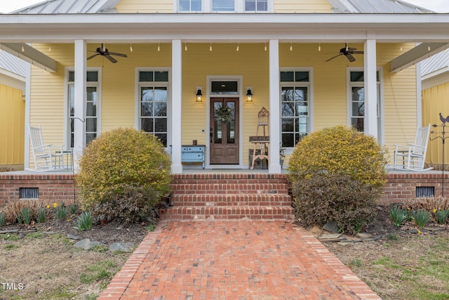 doorway to property featuring ceiling fan, metal roof, a porch, and a standing seam roof