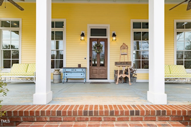 doorway to property with ceiling fan and a porch