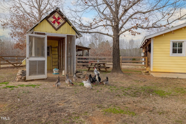 view of outbuilding featuring an outdoor structure and fence