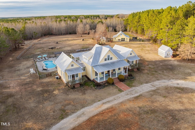 birds eye view of property featuring a view of trees