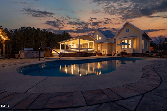 outdoor pool with a patio and area for grilling