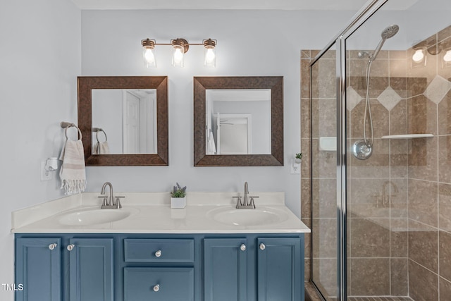 full bathroom featuring double vanity, a shower stall, and a sink