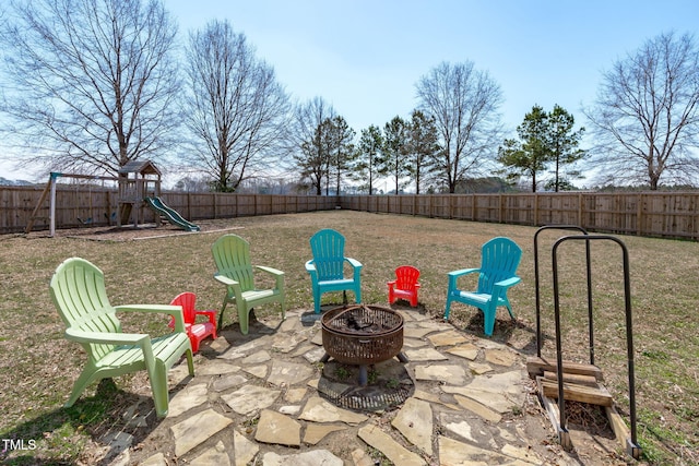 view of patio featuring an outdoor fire pit, a playground, and a fenced backyard