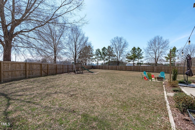 view of yard with a fenced backyard and a playground