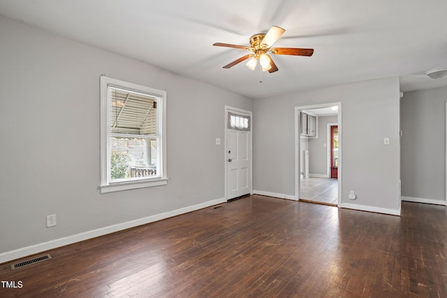 interior space with visible vents, a ceiling fan, baseboards, and hardwood / wood-style flooring