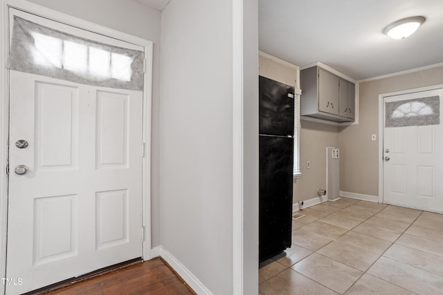 entryway with light tile patterned flooring and baseboards