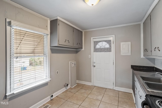 clothes washing area with baseboards, laundry area, light tile patterned flooring, a sink, and washer hookup