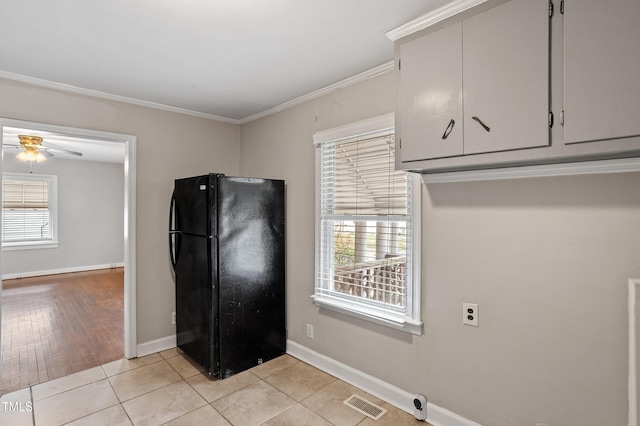 kitchen featuring light tile patterned floors, a ceiling fan, visible vents, freestanding refrigerator, and ornamental molding