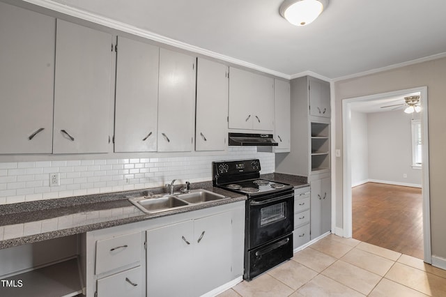 kitchen featuring dark countertops, black / electric stove, under cabinet range hood, and a sink