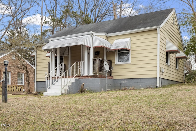 view of front facade featuring a front yard and roof with shingles