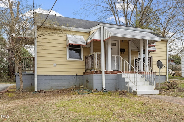 view of front facade featuring a front yard and a shingled roof