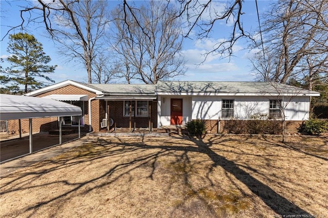 single story home featuring a front lawn, a carport, and brick siding