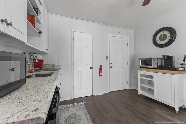 kitchen with open shelves, stainless steel dishwasher, dark wood-style flooring, and white cabinetry