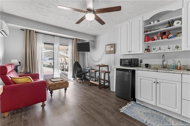 kitchen featuring light countertops, white cabinetry, a sink, black microwave, and fridge