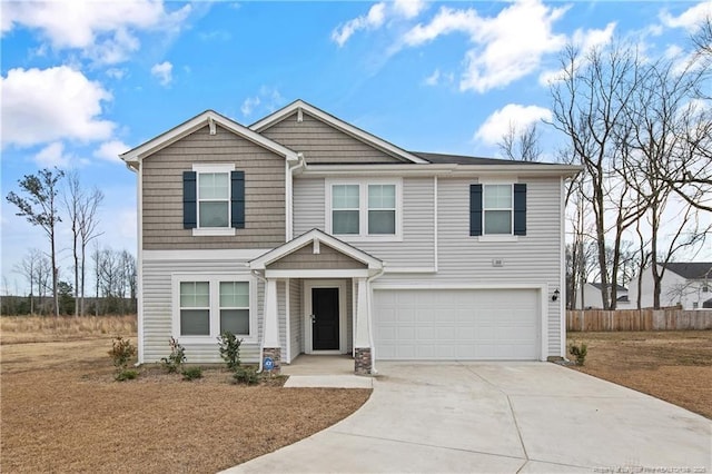 craftsman-style home featuring a garage, concrete driveway, and fence