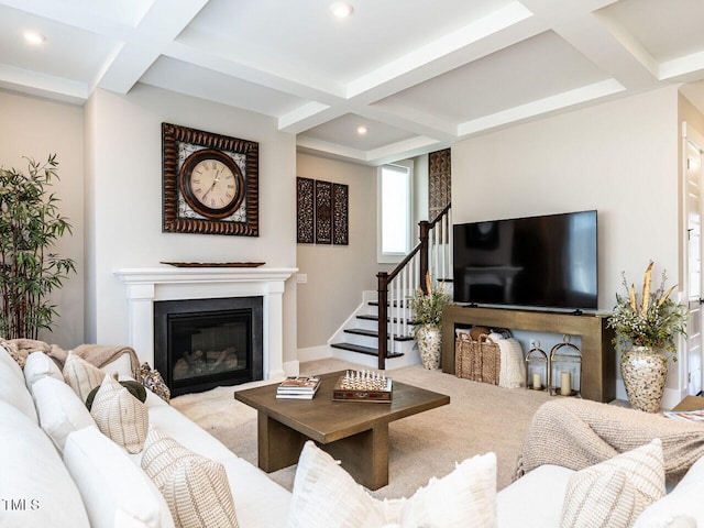 living area with coffered ceiling, a glass covered fireplace, stairway, beam ceiling, and recessed lighting