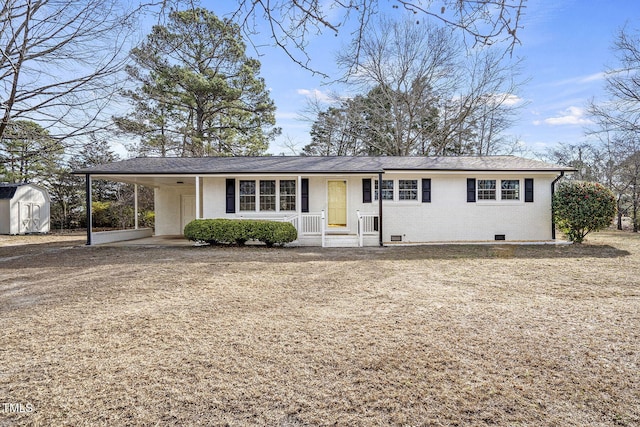 ranch-style house featuring an attached carport, crawl space, an outdoor structure, a shed, and brick siding