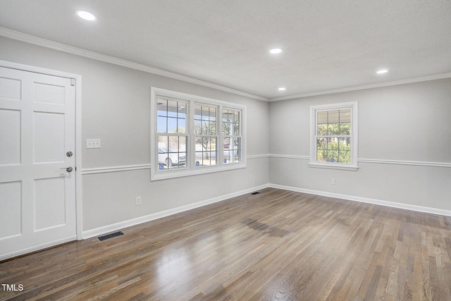 interior space featuring wood finished floors, visible vents, and crown molding