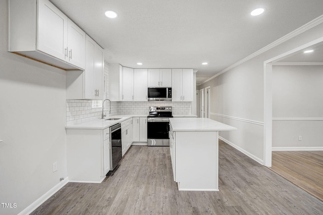 kitchen with appliances with stainless steel finishes, light countertops, and white cabinetry