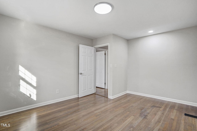 interior space featuring baseboards, visible vents, wood finished floors, and recessed lighting