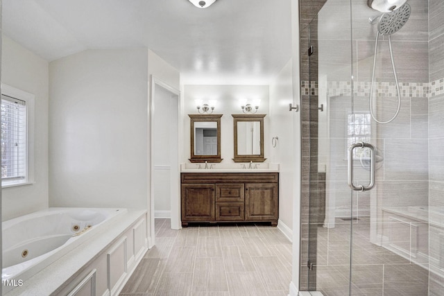 bathroom featuring a sink, double vanity, a whirlpool tub, and a shower stall