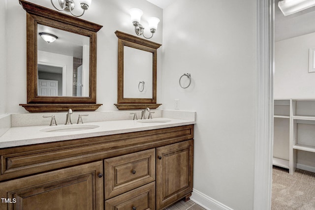 full bath with double vanity, baseboards, and a sink