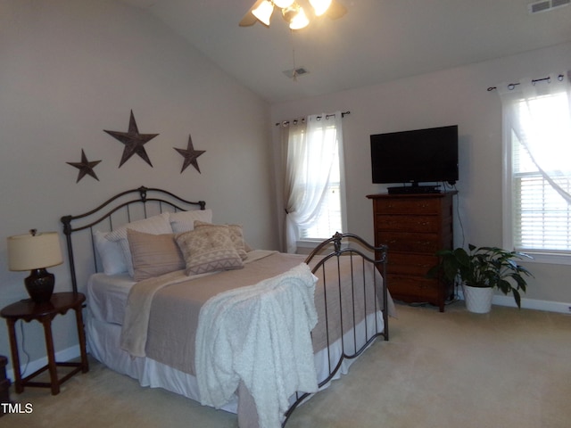 carpeted bedroom with lofted ceiling, baseboards, visible vents, and a ceiling fan